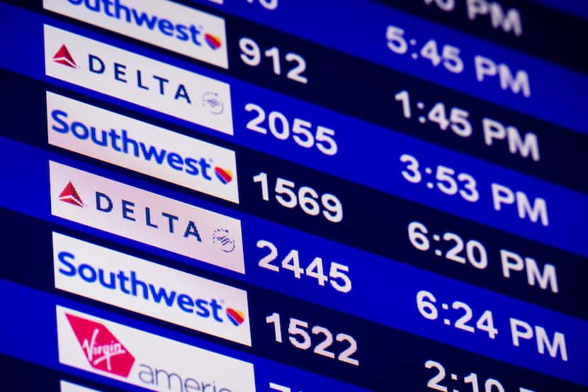  A message board shows the status for Delta, Southwest and Virgin America departing flights...