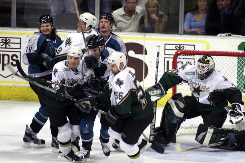 FILE - Dallas and San Jose players fight for the puck in front of Stars goalie Ed Belfour...