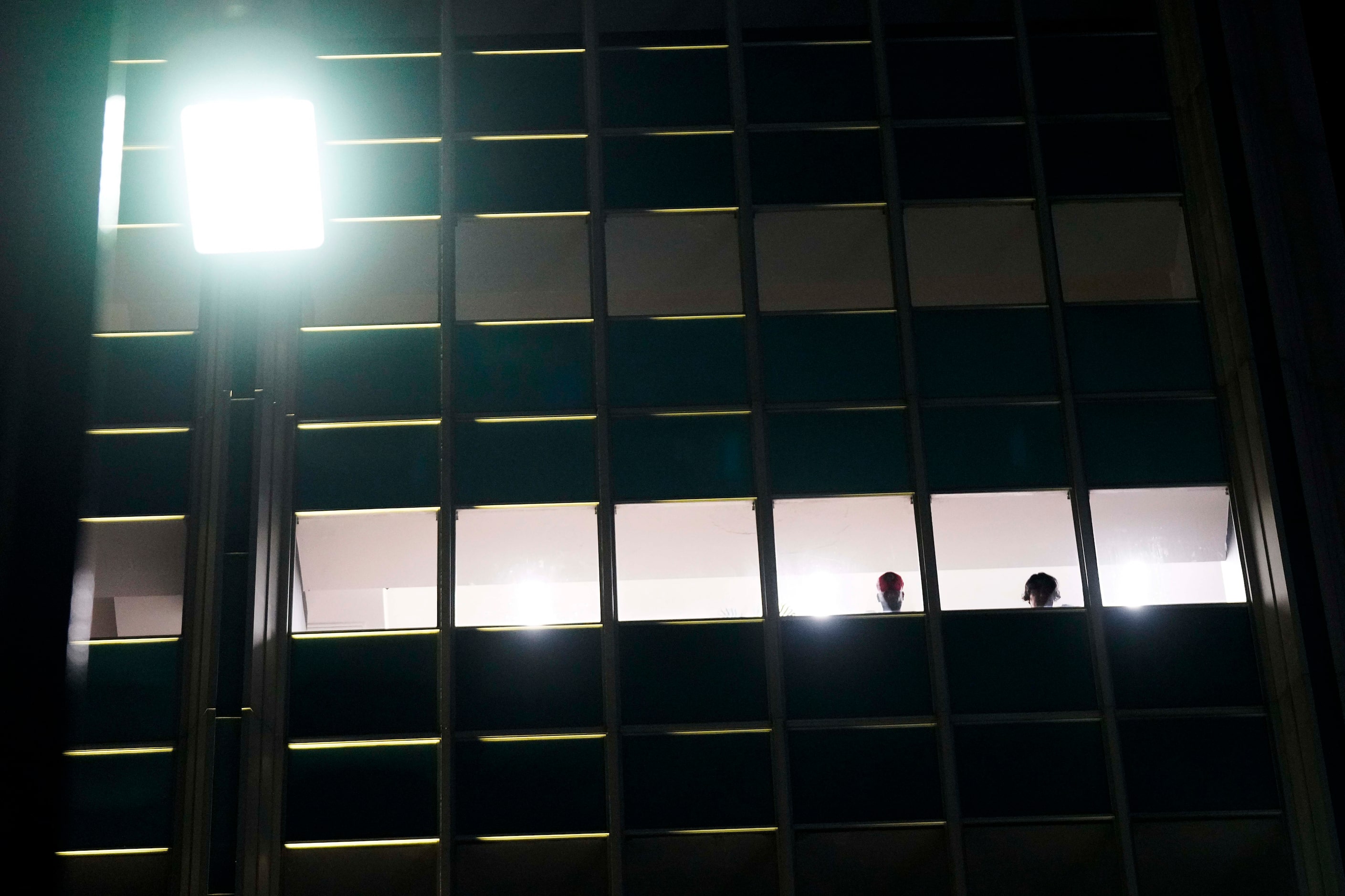 People watch from window of a building on Elm Street at Ervay as Dallas police and  Texas...