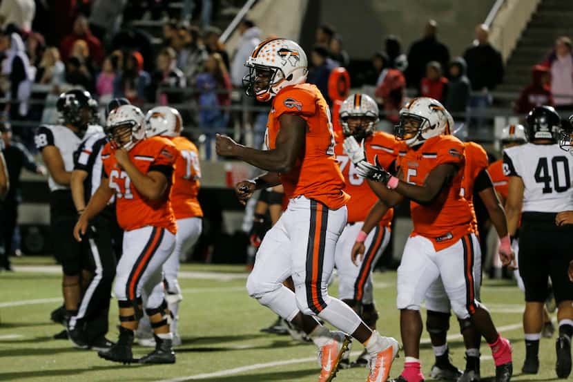 Haltom quarterback Adam Hill (10) celebrates at they defeated Euless Trinity during their...