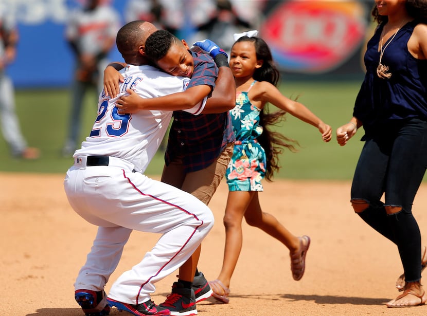 Texas Rangers Adrian Beltre (29) hugs his son Adrian Jr. and daughters Canila and Cassandra...
