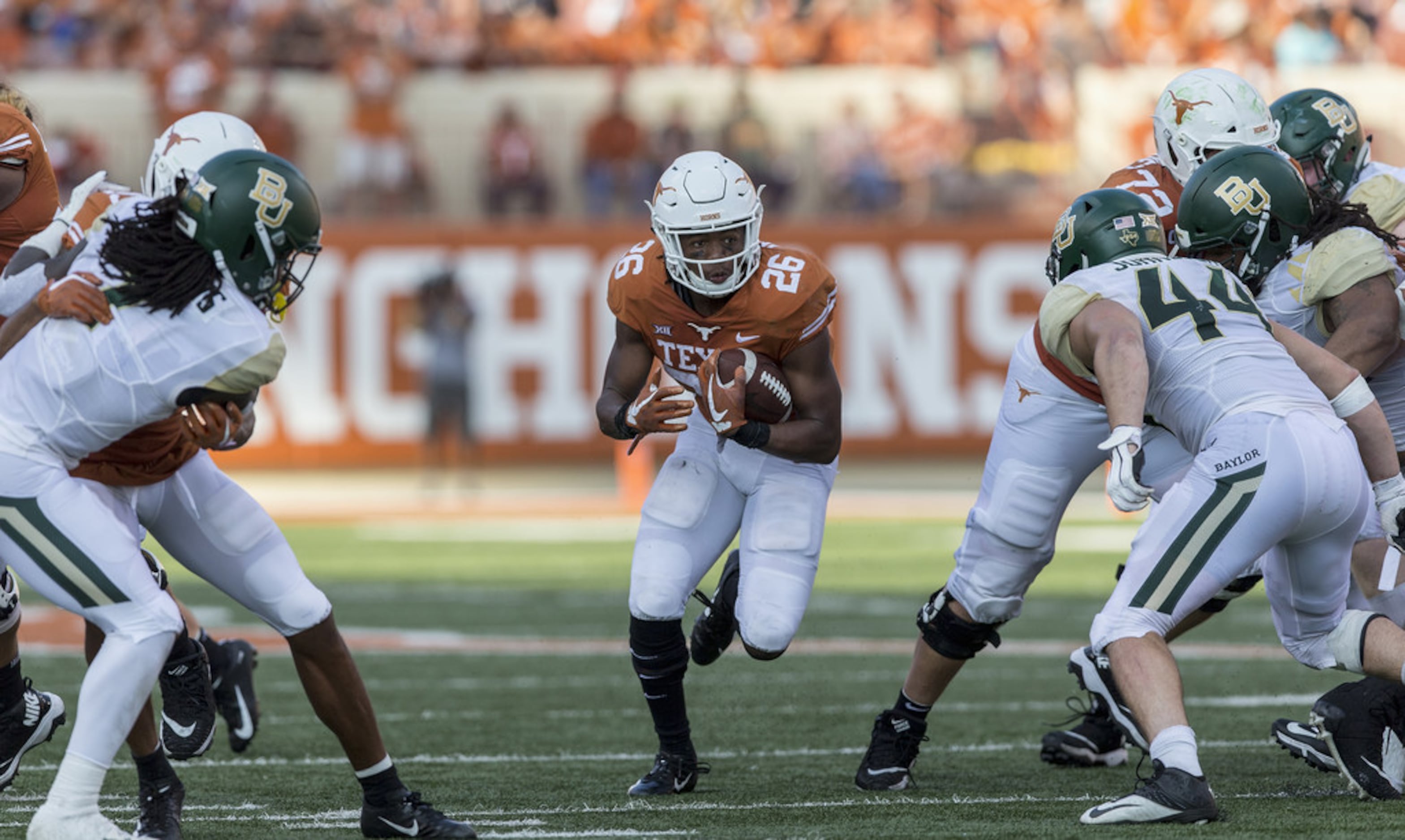 Texas Longhorns running back Keaontay Ingram (26) is stopped behind the  line by Oklahoma defensive lineman Kenneth Mann (55) during the Dr. Pepper  Big-12 Championship between the Oklahoma Sooners vs Texas Longhorns