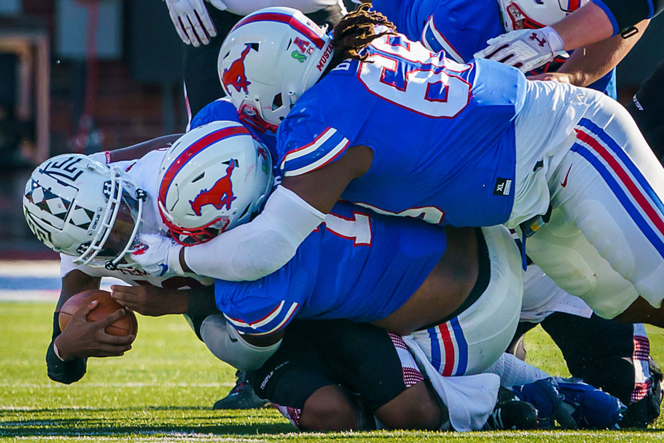 Temple quarterback Todd Centeio (16) is brought down by SMU defensive tackles Demerick Gary...