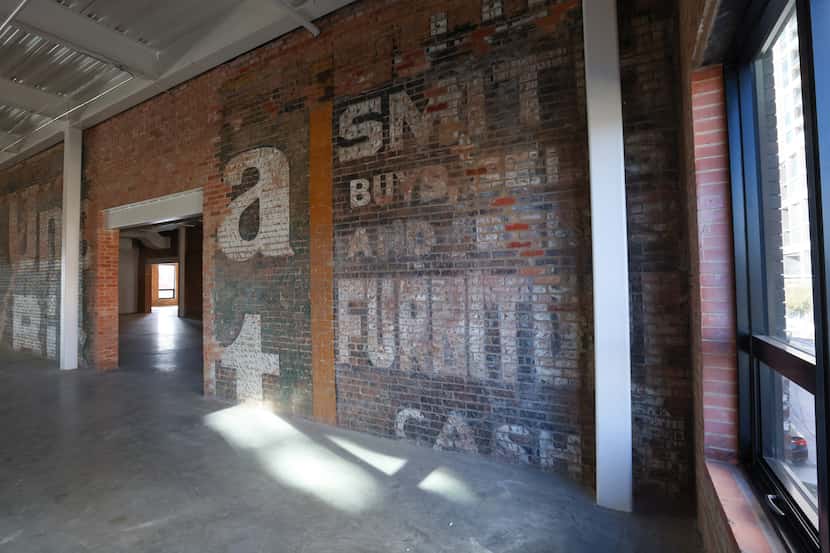 Office space by developer Westdale includes exposed brick walls with painted advertisements...