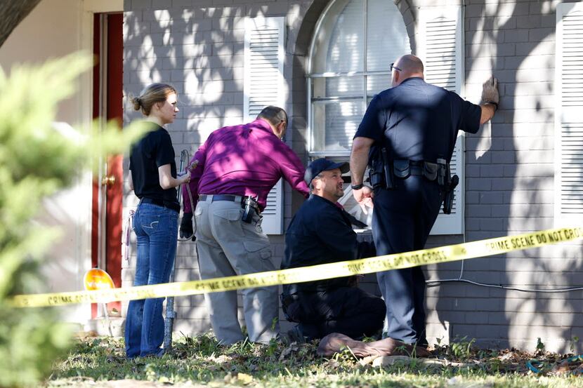 Police investigate the scene where an Arlington homeowner shot two alleged intruders who...