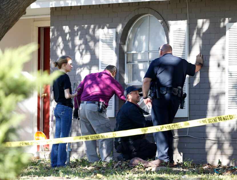 Police investigate the scene where an Arlington homeowner shot two alleged intruders on...