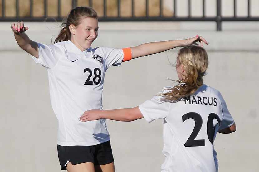 Marcus forward Kelly VanGundy (28) is embraced by midfielder Nina Mazzola (20) after...