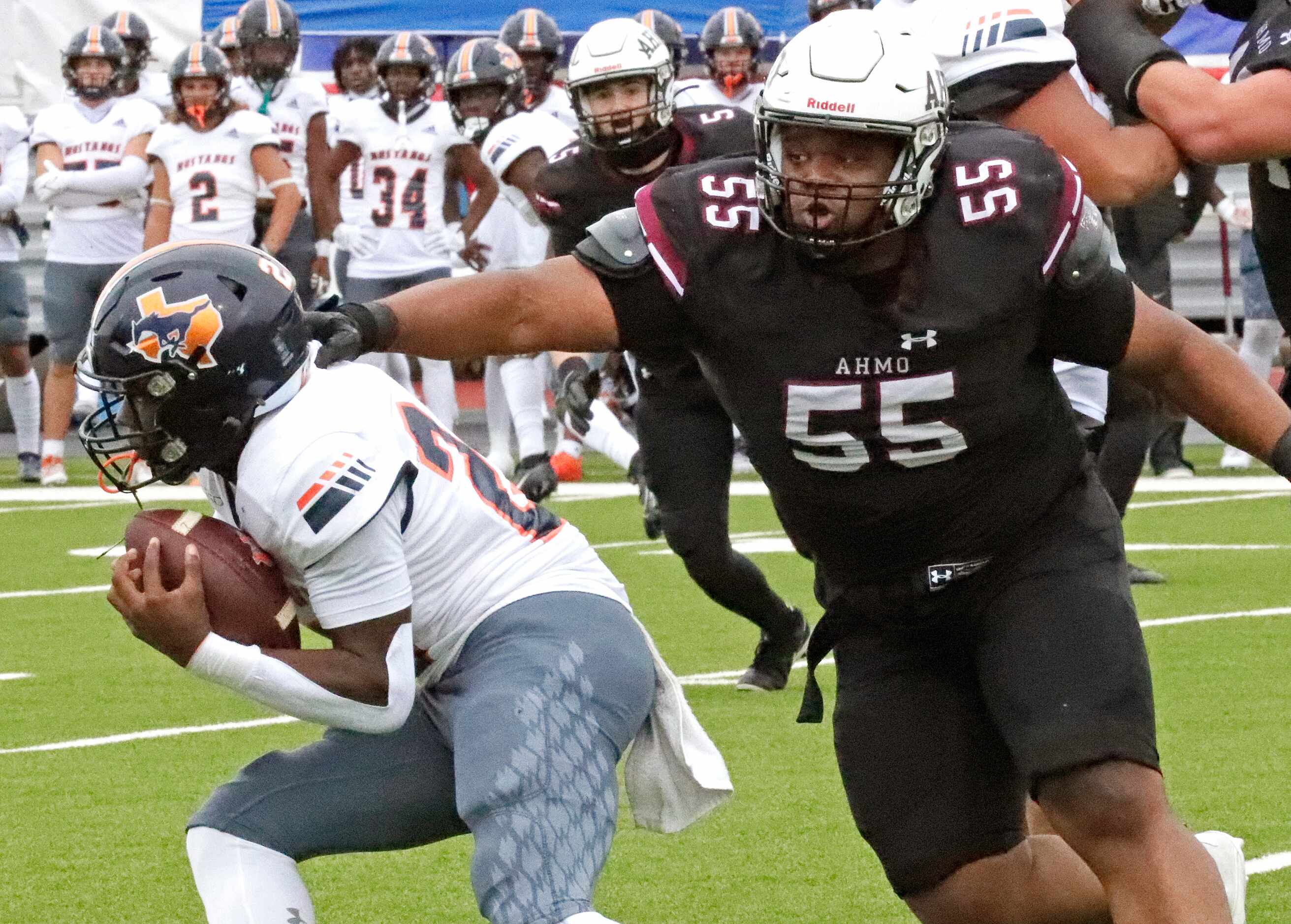 Wylie High School defensive lineman Cam Draper (55) reaches to tackle Sachse High School...