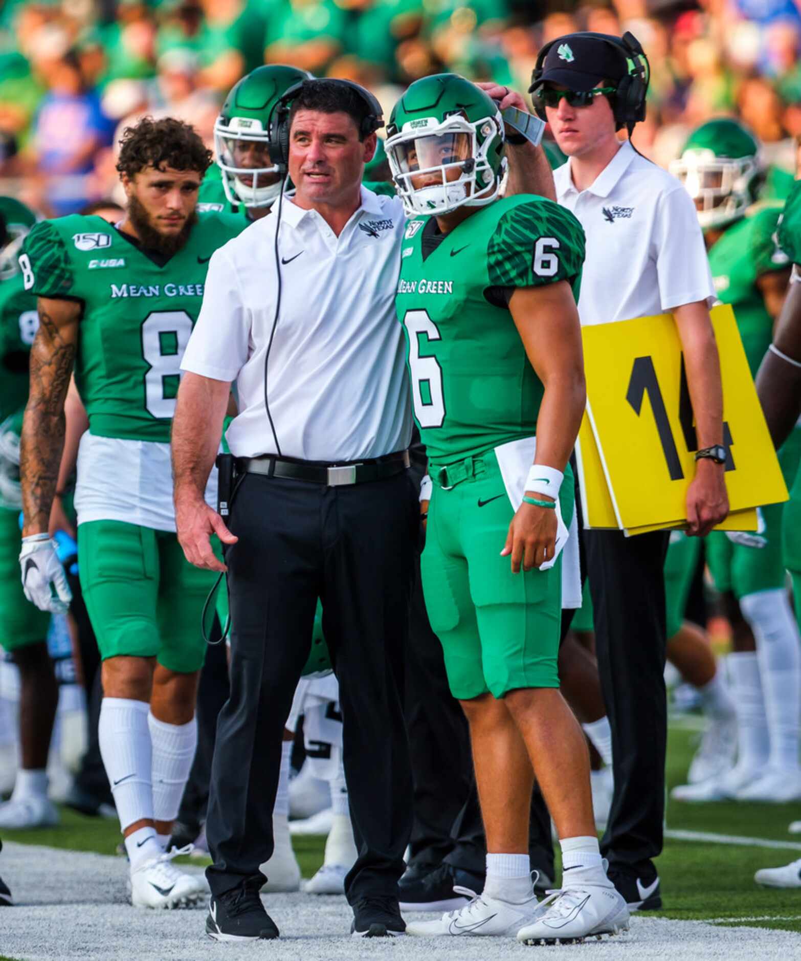 UNT head coach Seth Littrell talks with quarterback Mason Fine on the sidelines during the...