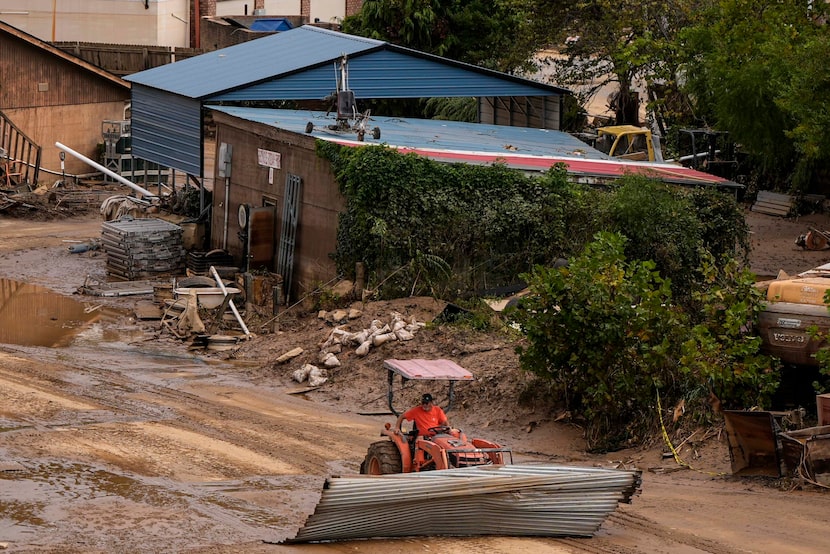 A worker moves debris in the aftermath of Hurricane Helene, Monday, Sept. 30, 2024, in...