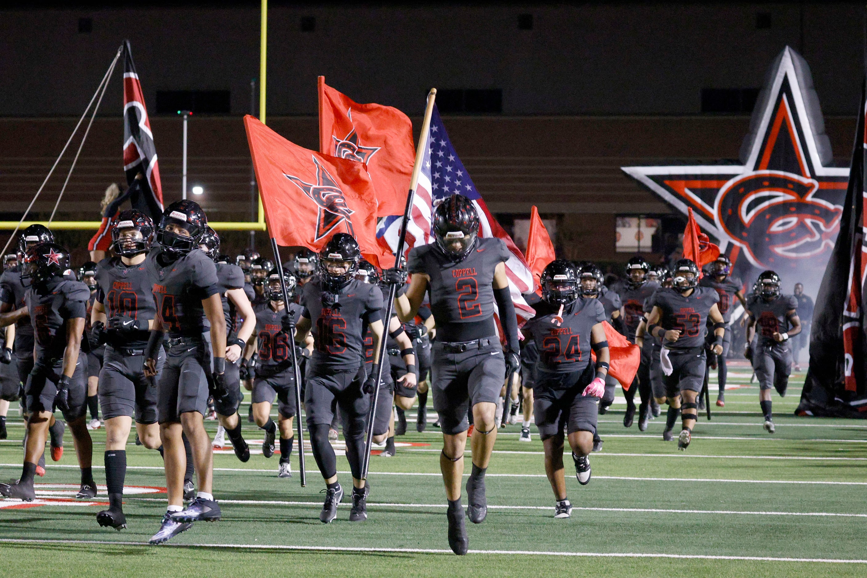 Coppell players run out to the field before a high school football game against Prosper at...