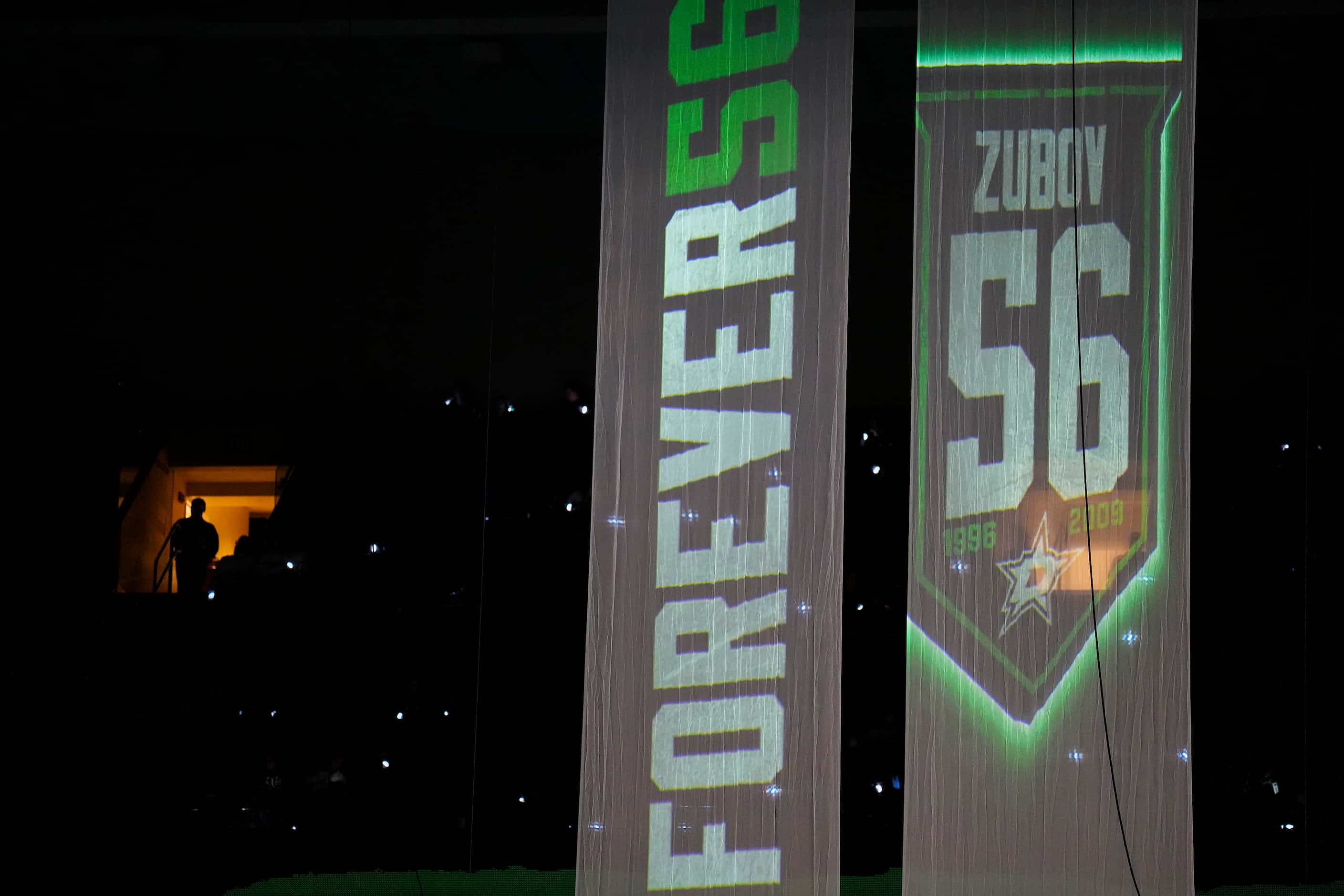 Banners honoring former Dallas Stars player Sergei Zubov are illuminated for his jersey...