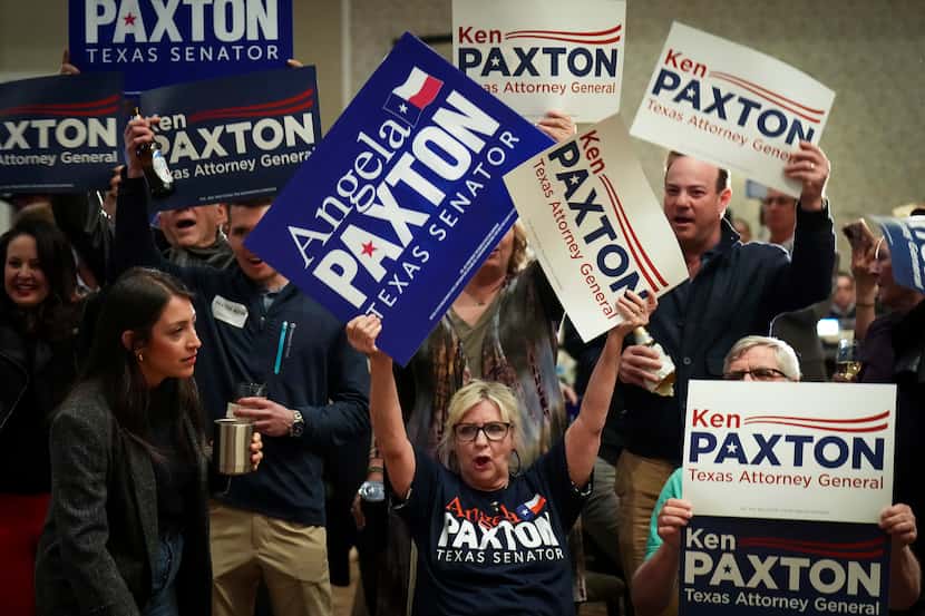 Supporters cheer and waves signs during a primary election night event for Texas Attorney...