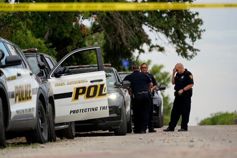 Police protect the scene where officials say dozens of people were found dead and multiple...
