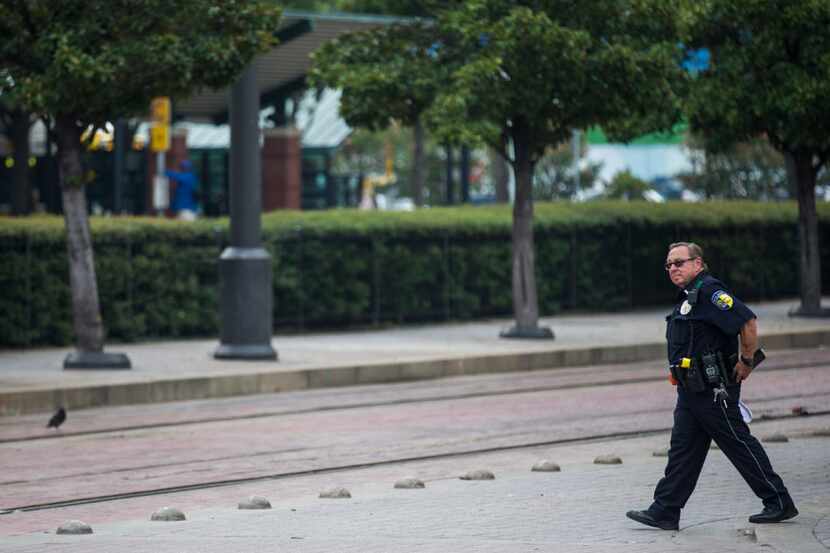 A DART officer walks across the tracks at the West End DART station on Aug. 3 in downtown...