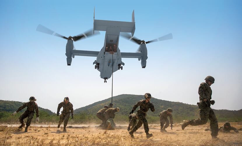 U.S. Marines evacuate the area as an MV-22B Osprey comes into land at Hat Yao, Thailand...