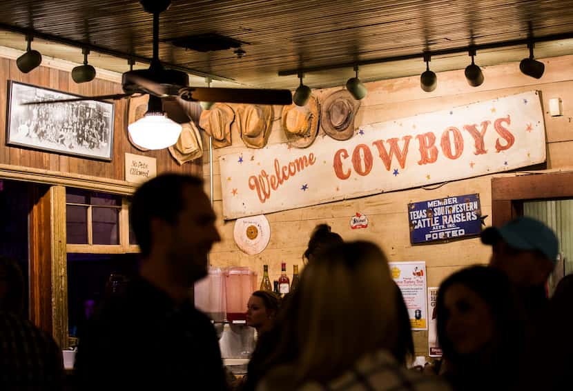 A "Welcome Cowboys" sign is displayed above the bar at Gruene Hall, shown in 2015. 