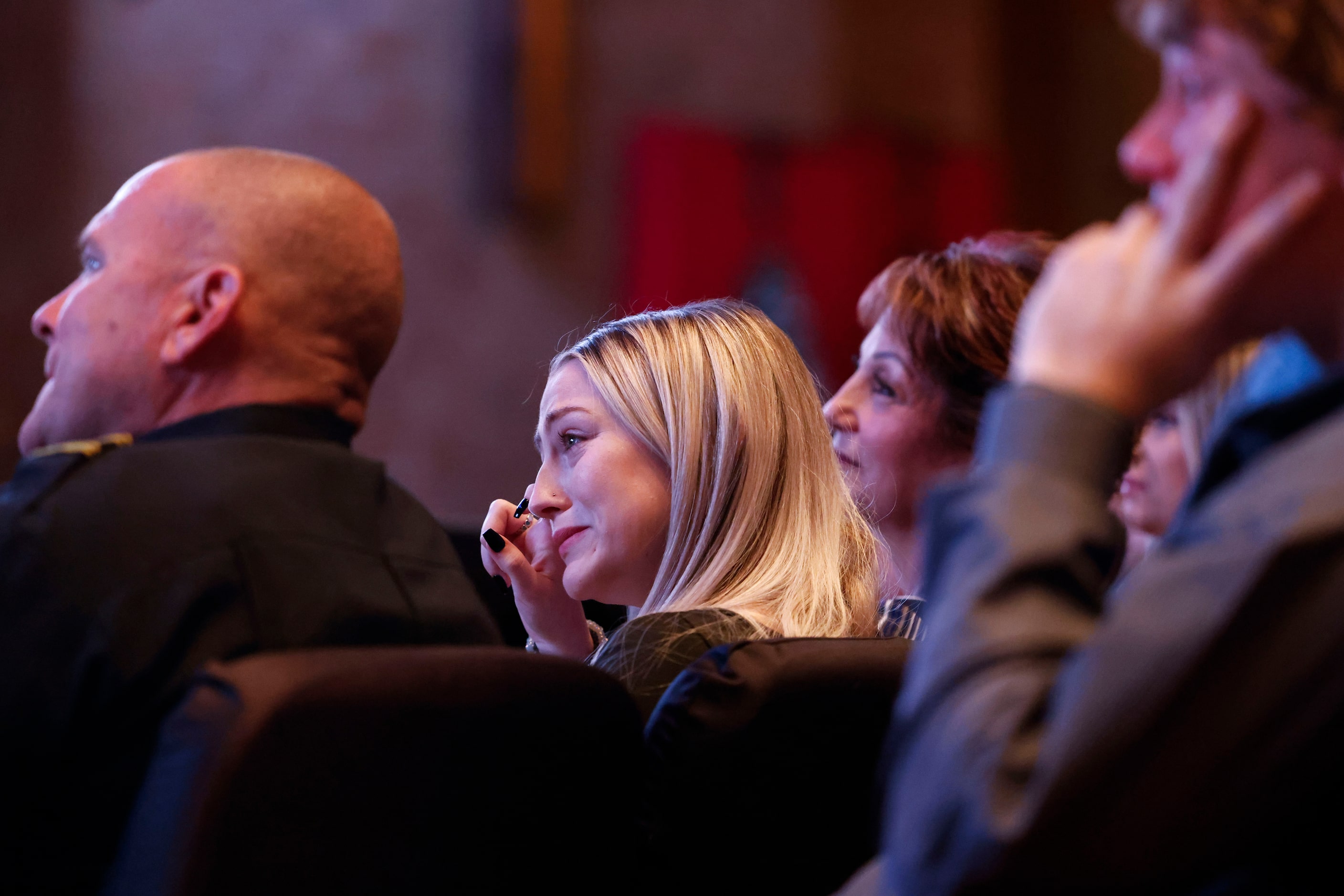 Aubrey Dawson, wipes away tears as she watches a slideshow shown during a funeral service...