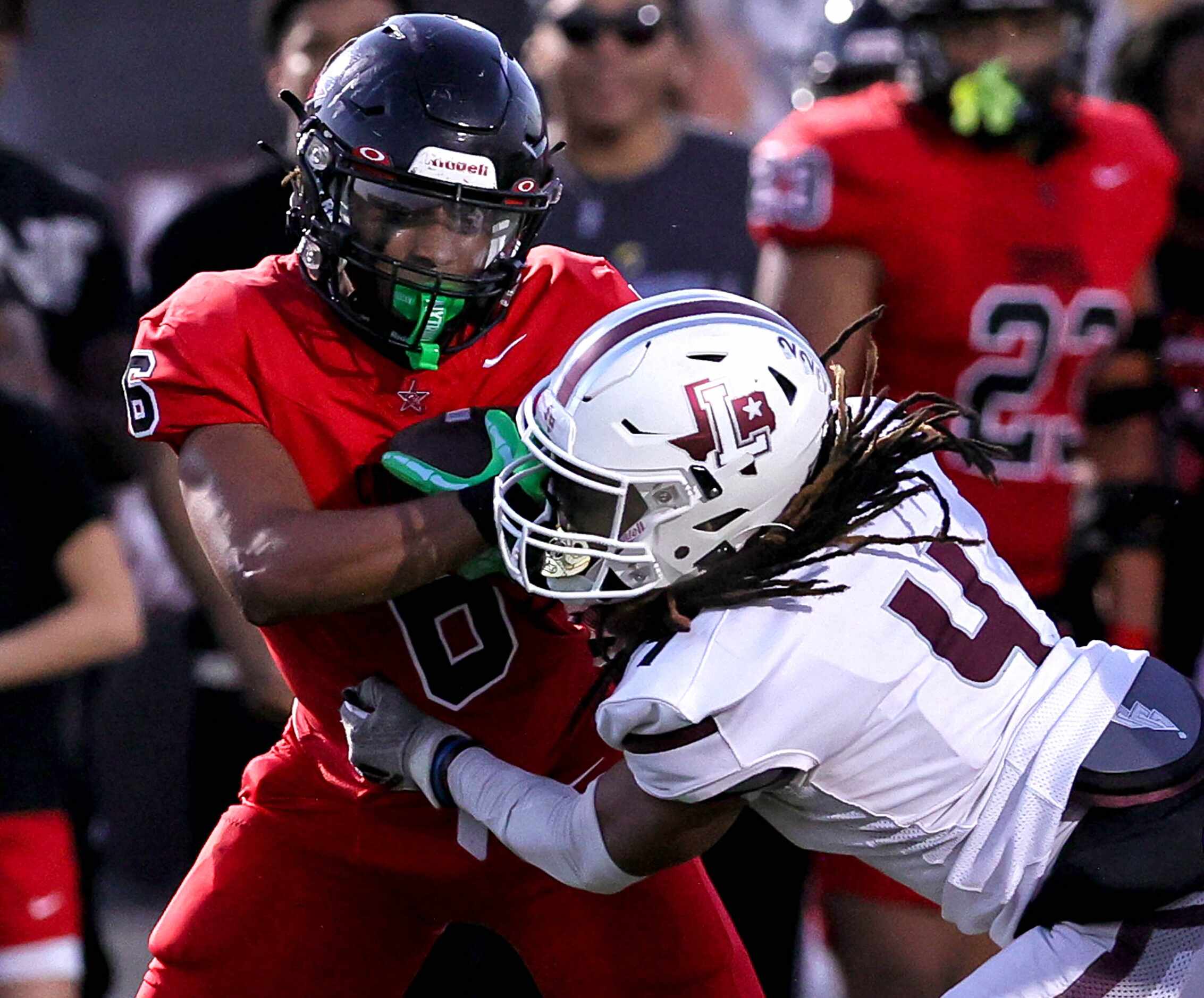Coppell running back O'Marion Mbakwe (6) gets a hard hit by Lewisville defensive back...