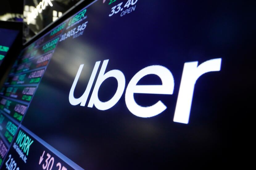 The logo for Uber appears above a trading post on the floor of the New York Stock Exchange.