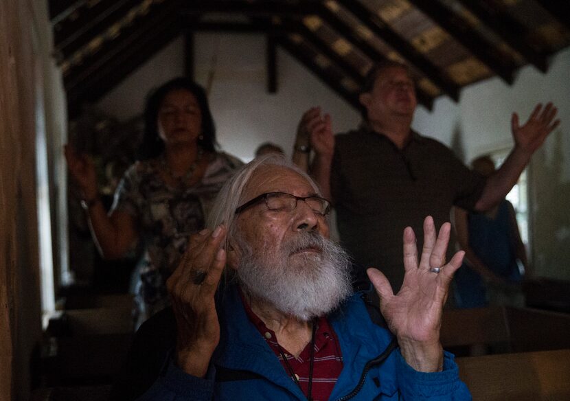 Jose Ramirez, a longtime attendee of Mass at La Lomita, holds up his hands in prayer during...