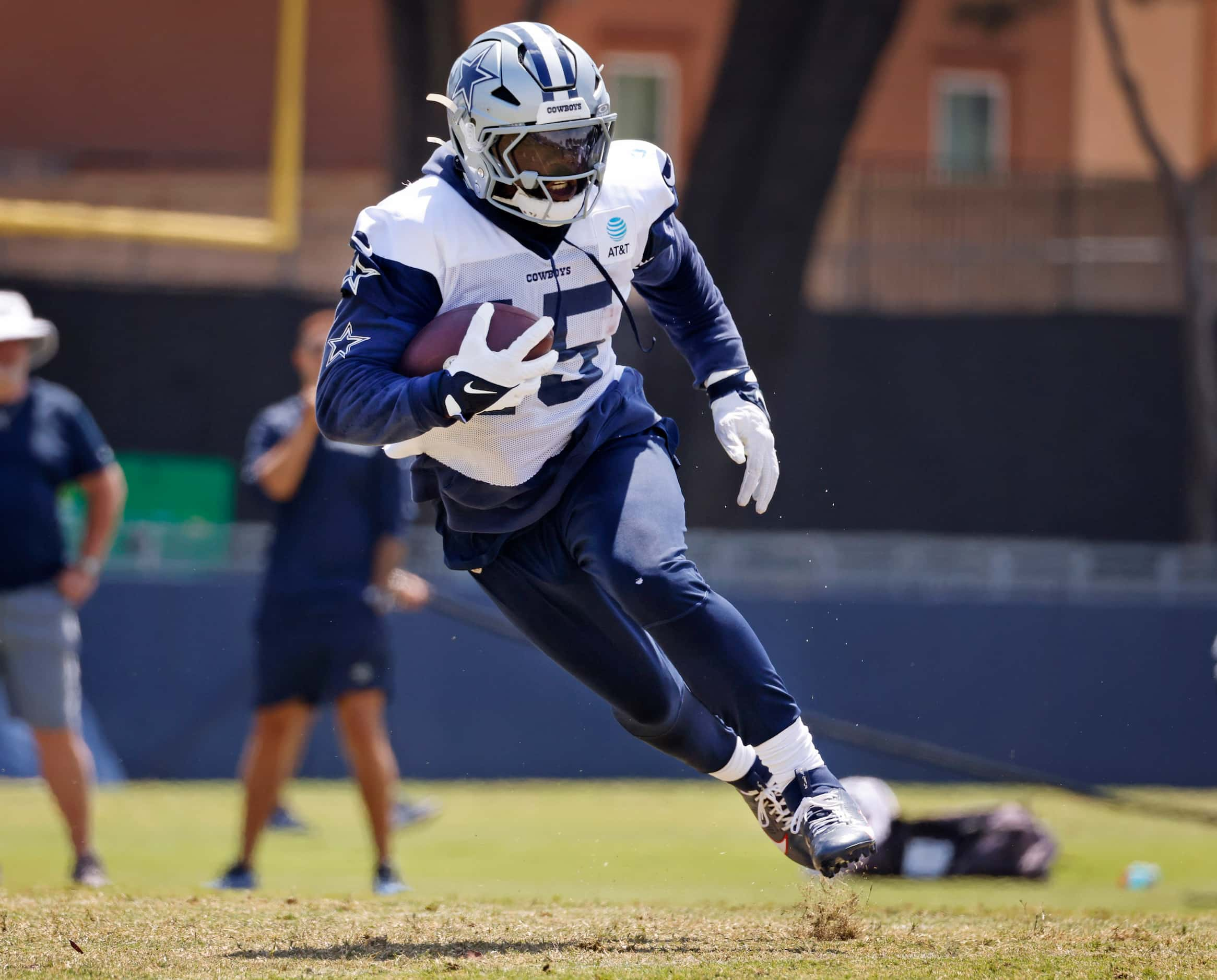 Dallas Cowboys running back Ezekiel Elliott (15) makes a cut after taking a hand off from...