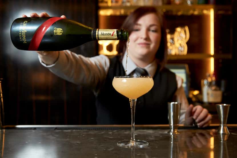 Bartender Shelby Hodges adds Champagne to top off an Uptown 86 cocktail at Beau Nash at...