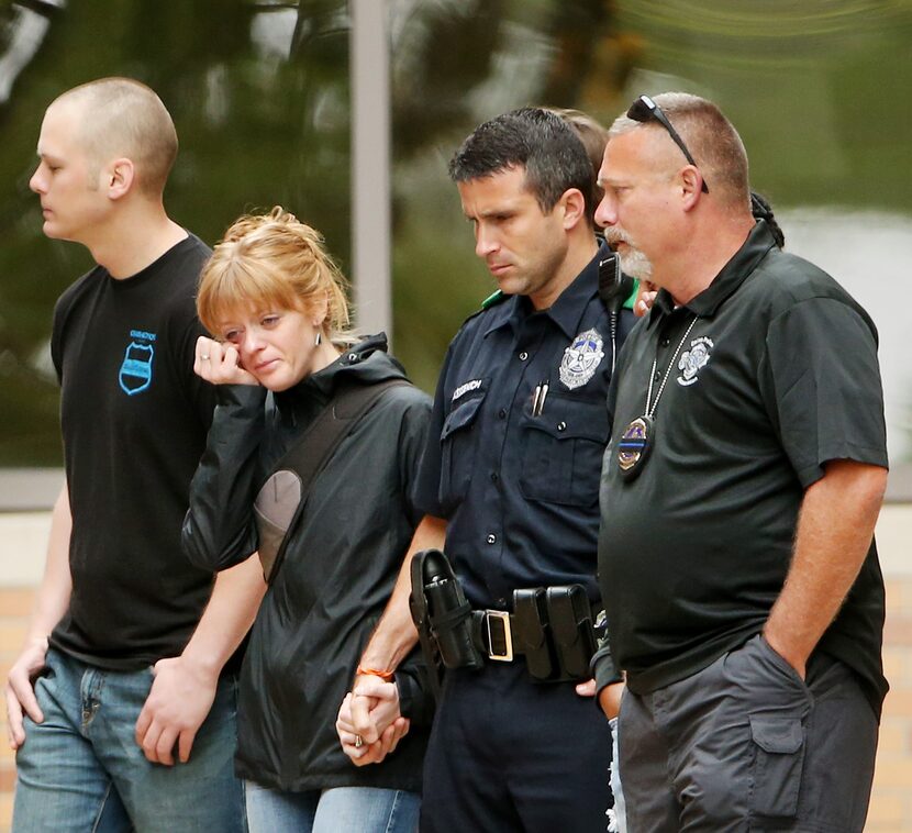 Mourners exit the emergency room of Texas Health Presbyterian Dallas after Police Chief U....