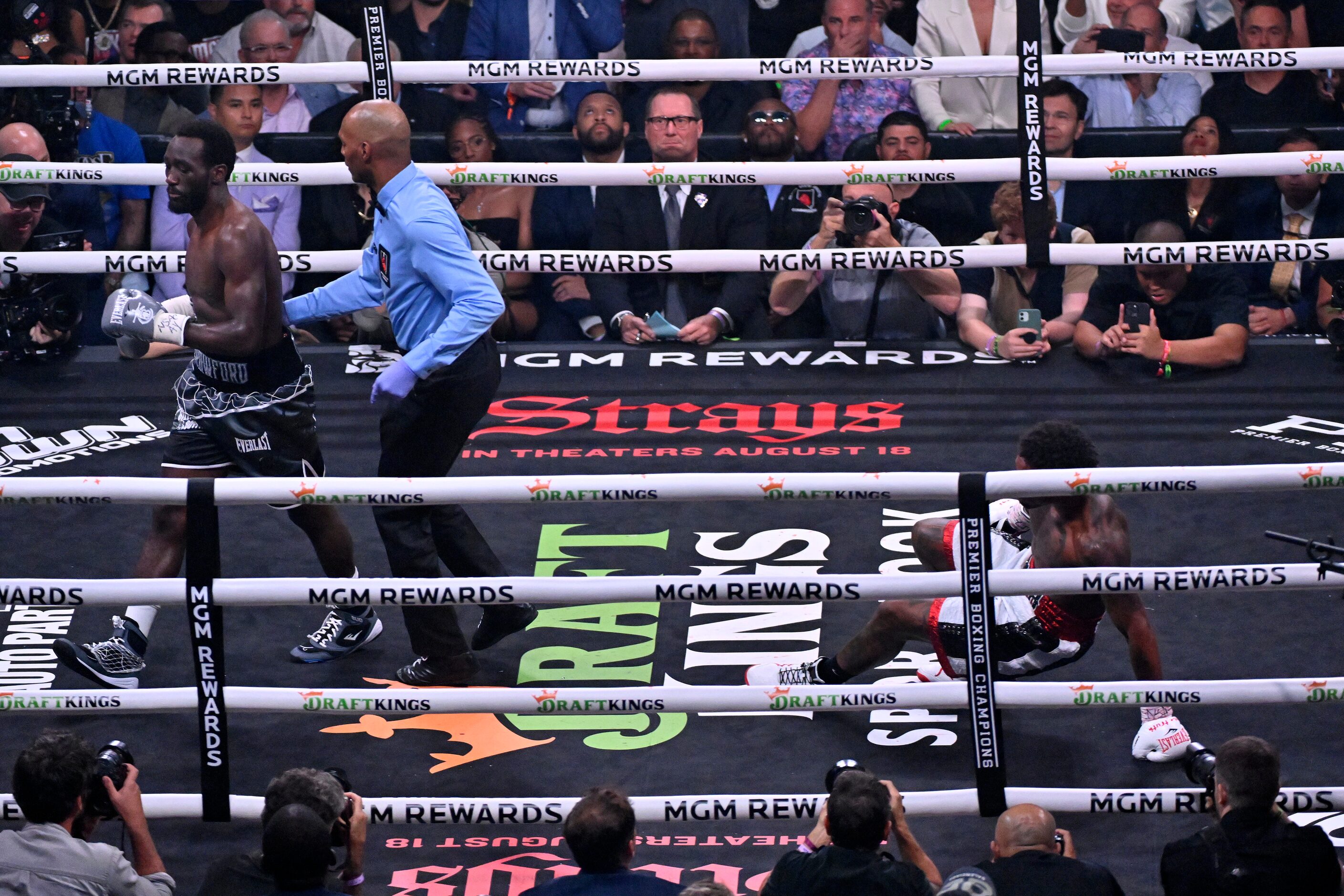 Terence Crawford, left, is moved aside by referee Harvey Dock after knocking down Errol...