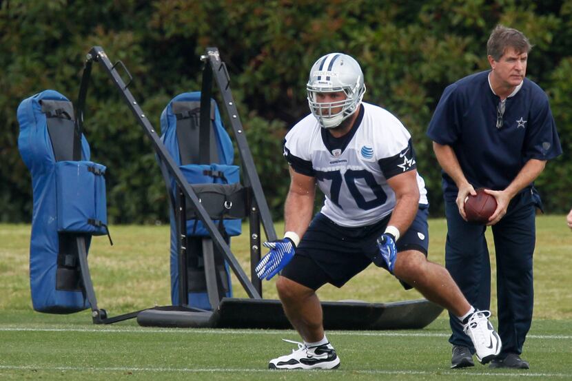 Dallas Cowboys center Travis Frederick (70) gets instruction from offensive line coach Bill...