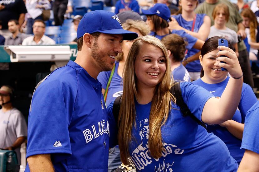J.P. Arencibia #9 of the Toronto Blue Jays poses for a photo with a fan before the start of...