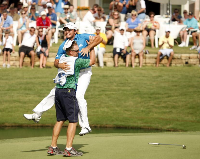 Jason Day celebrates with his caddy Colin Swatton after Day sinked his putt and winning the...