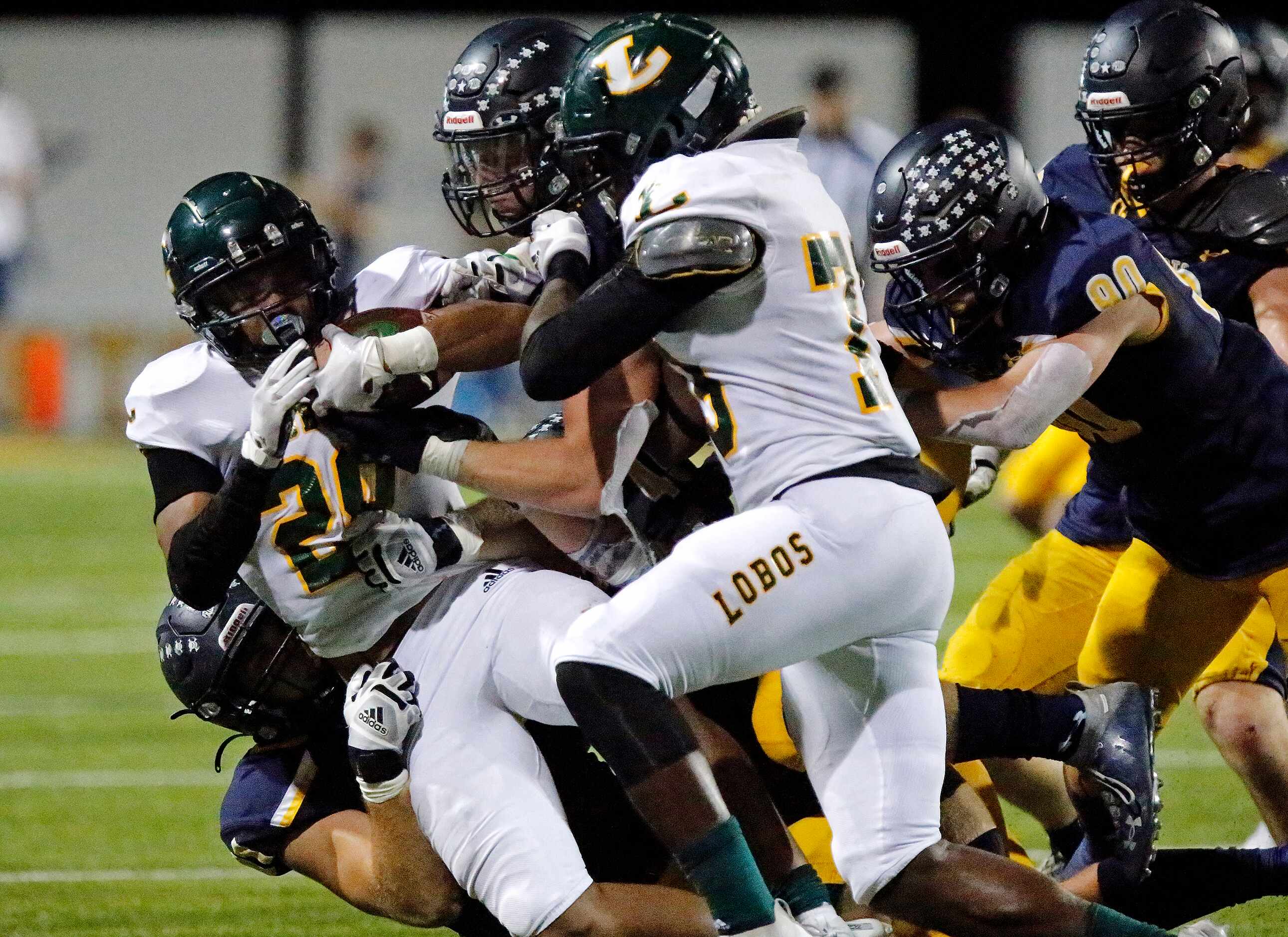 Longview High School running back Taylor Tatum (28) is brought down by Highland Park High...