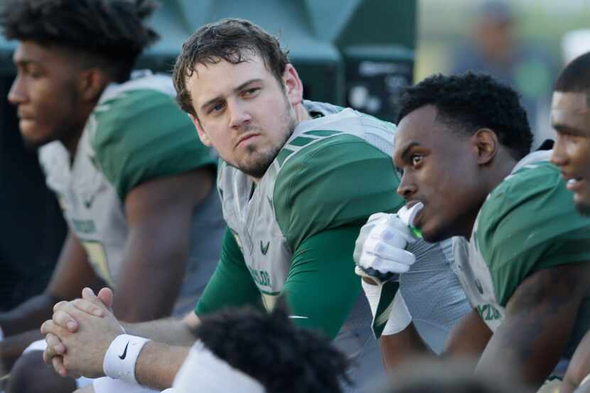 Baylor quarterback Seth Russell, center, sits on the sidelines during the second half of an...