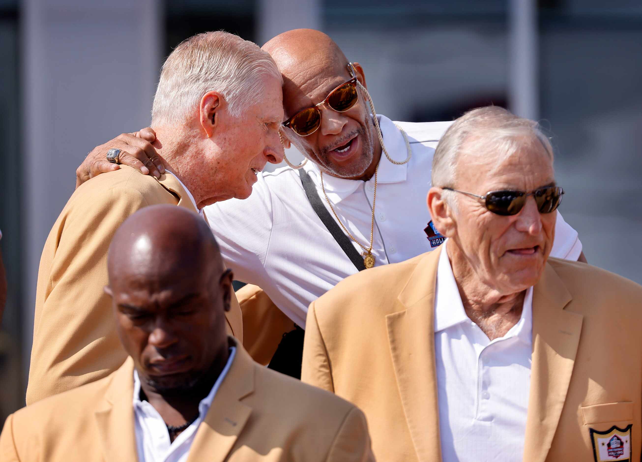 Pro Football Hall of Fame inductee Drew Pearson (back right) embraces fellow Dallas Cowboys...
