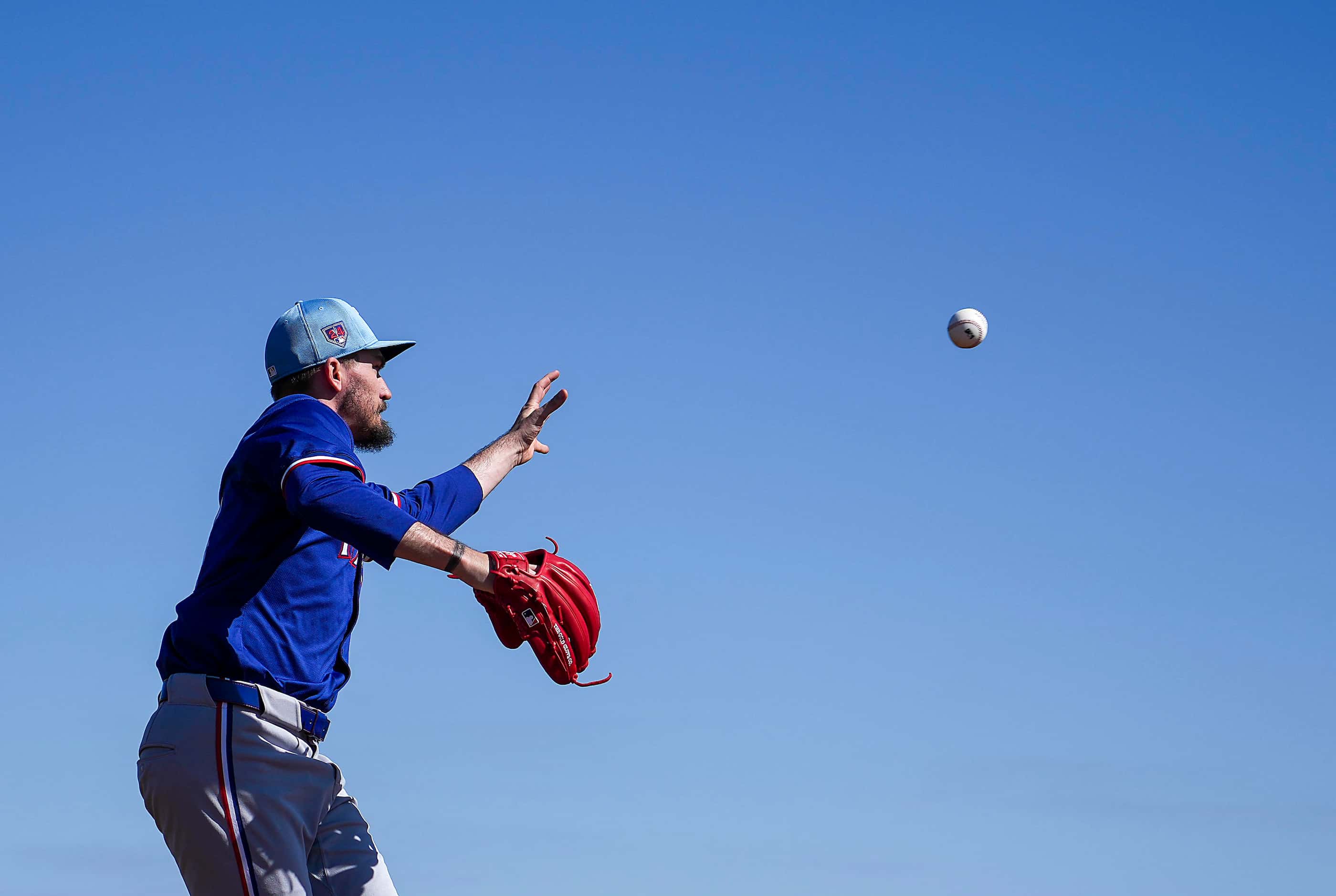 Texas Rangers pitcher Andrew Heaney participates in a fielding drill during a spring...