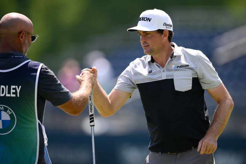Keegan Bradley, right, fist bumps his caddie as he finished his round on the 18th green...