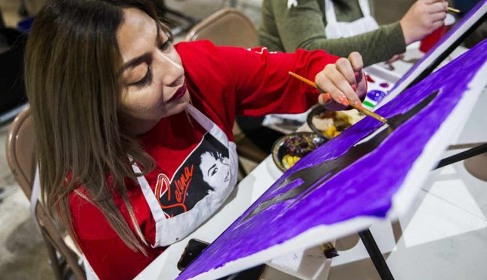 
				Priscilla DeLeon trabaja en su lienzo durante un taller de pintura enfocado en Selena,...