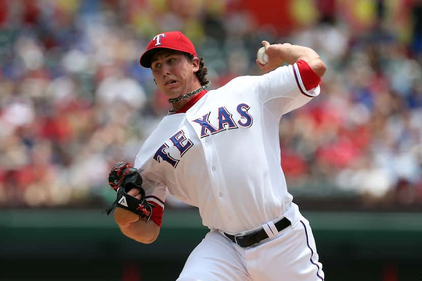 ARLINGTON, TX - JULY 25: Starting pitcher Derek Holland #45 of the Texas Rangers pitches...