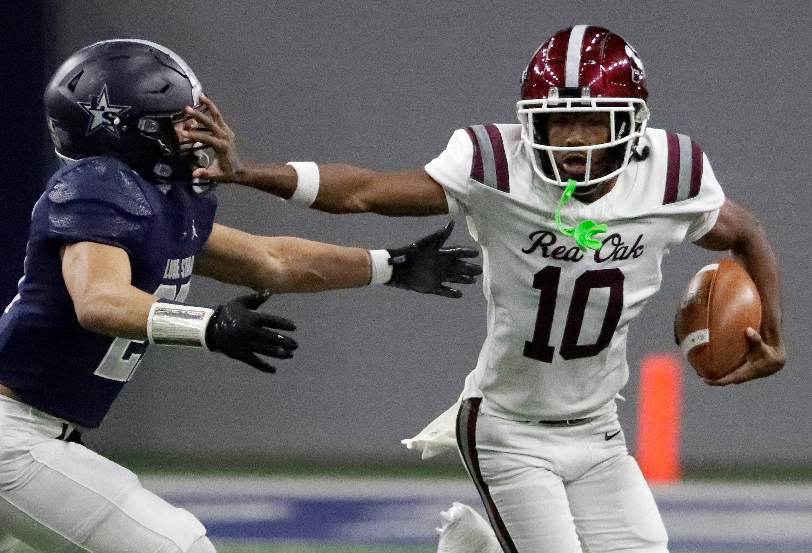 Red Oak High School quarterback Billy Middleton (10) stiff arms Lone Star High School...