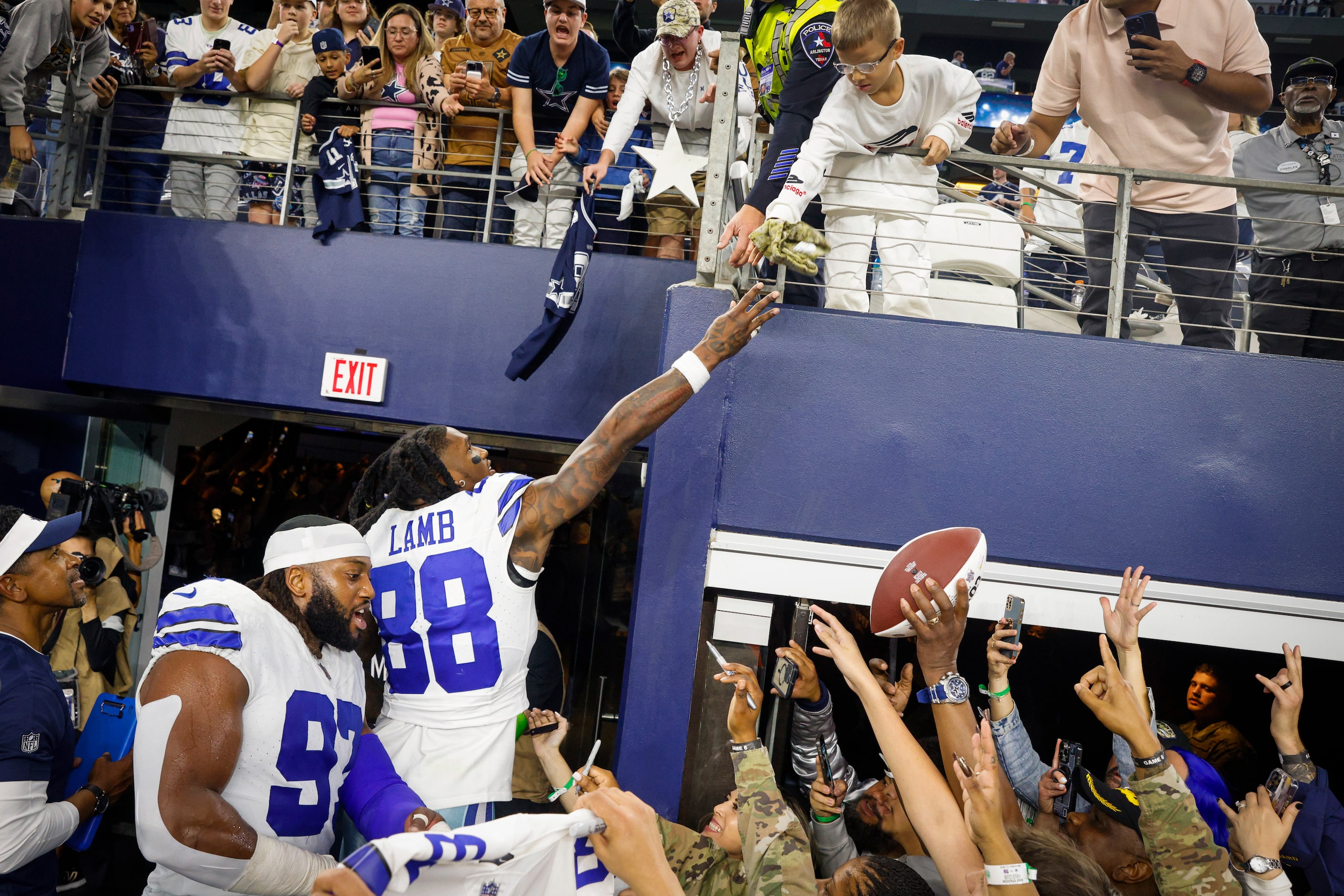 Dallas Cowboys wide receiver CeeDee Lamb (88) tosses his hat to a young fan after an NFL...