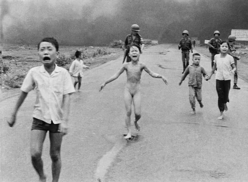 In this June 8, 1972, photo taken by Nick Ut, 9-year-old Kim Phuc (center) runs with her...