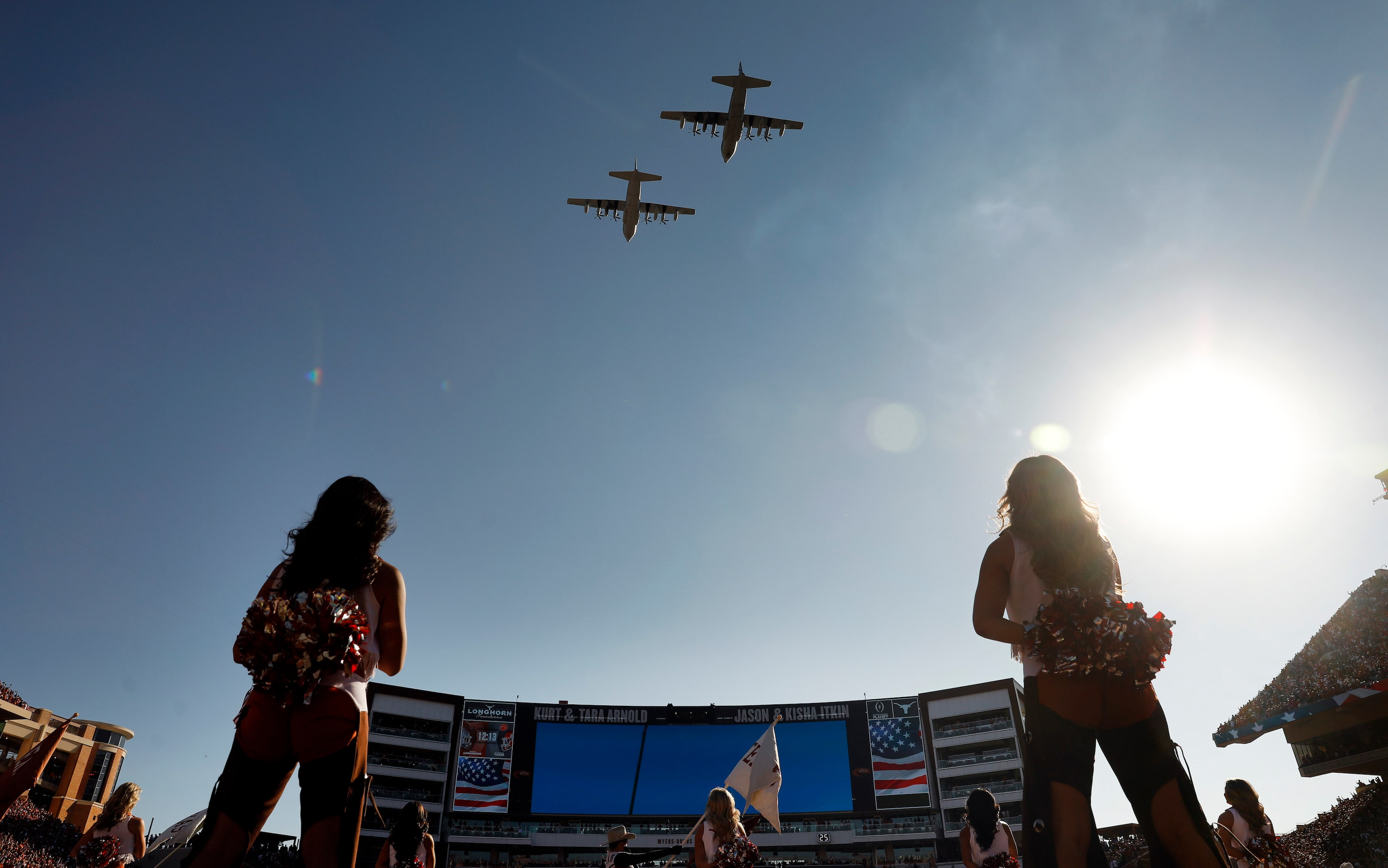 A pair of C-130 military aircraft flyover before the CFP first round playoff game between...