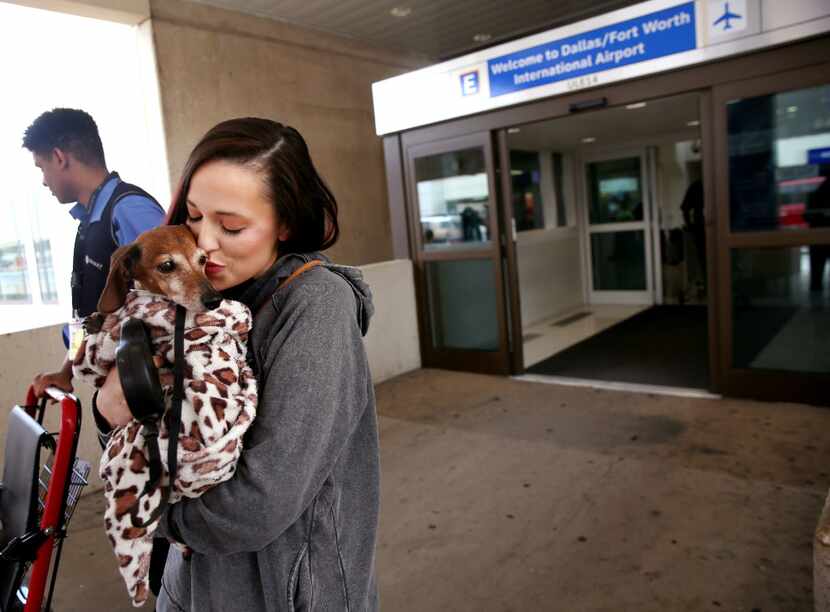 Donna Rosen kisses her dog Bobo while waiting for an Uber outside DFW International Airport....