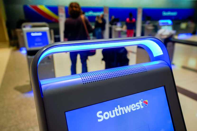 Travelers checked in for flights at the Southwest airlines ticket counters at Dallas Love...
