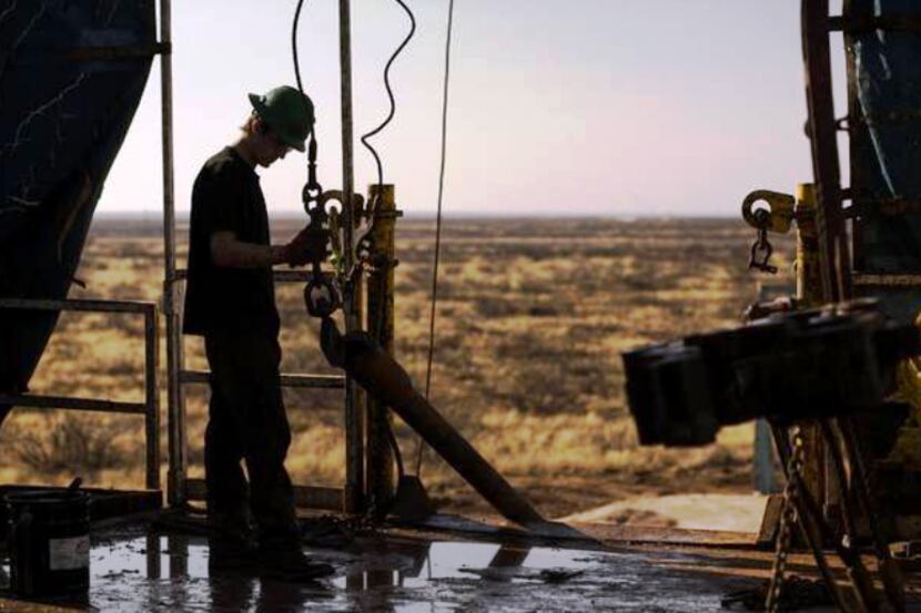 An oil field worker. The drop in oil prices is hurting top-oil producing states such as...