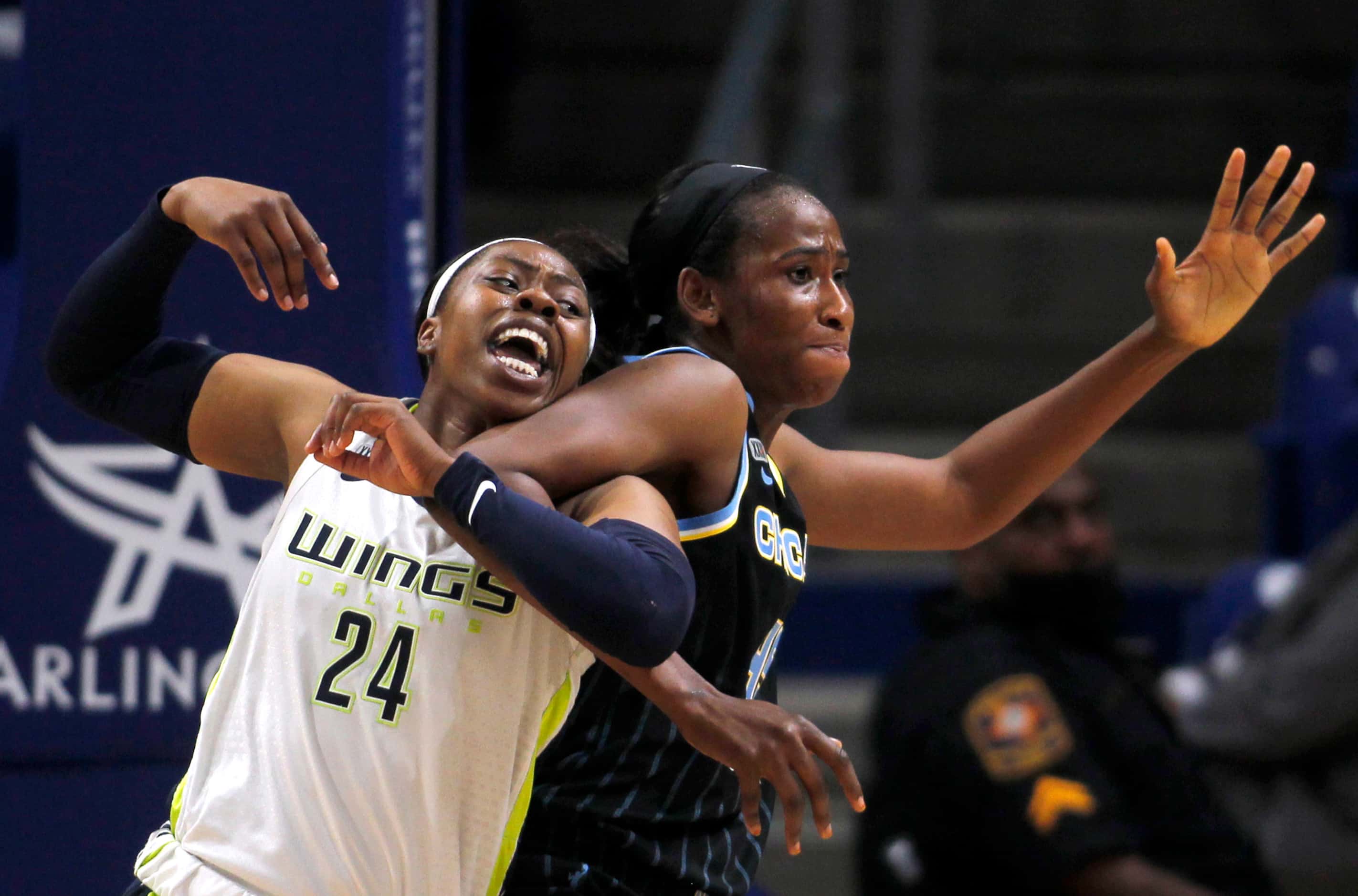 Dallas Wings guard Arike Ogunbowale (24) becomes tangled with Chicago Sky center Astou...