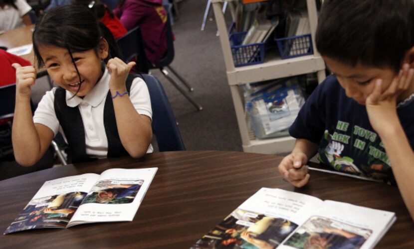 Mu Lar Hso, 9, gives a thumbs-up as she works on her English vocabulary lesson at Wallace...