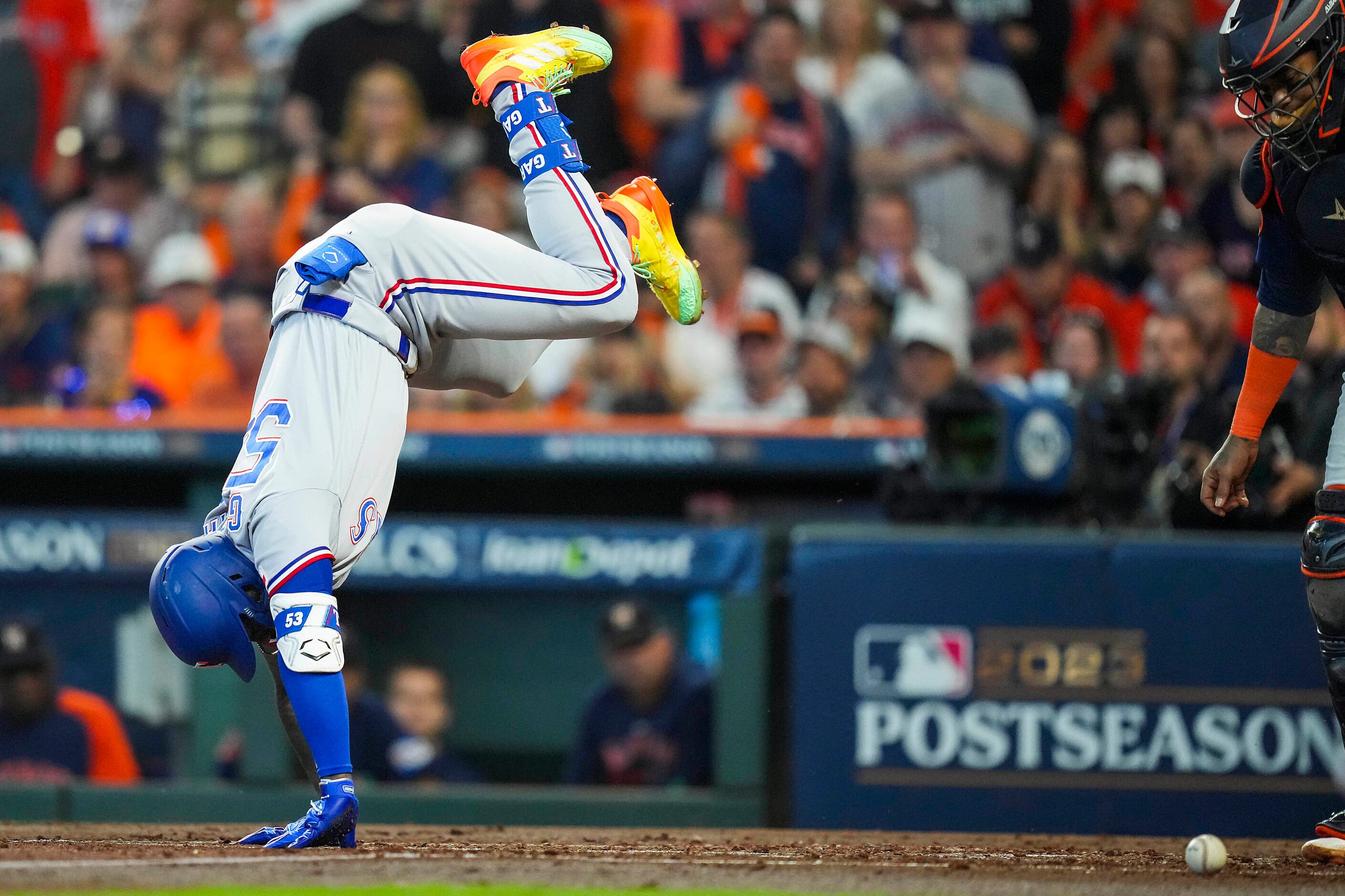 Texas Rangers right fielder Adolis Garcia tumbles after being hit by a pitch during the...