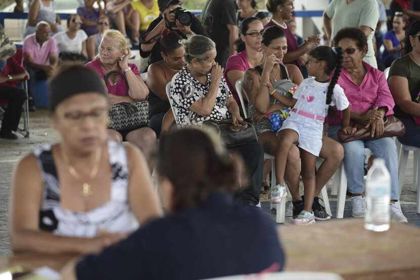 Un grupo de personas espera para llenar sus solicitudes de ayuda federal con FEMA en Las...